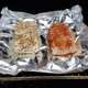 Two seasoned bricks of cream cheese on top of foil inside the smoker